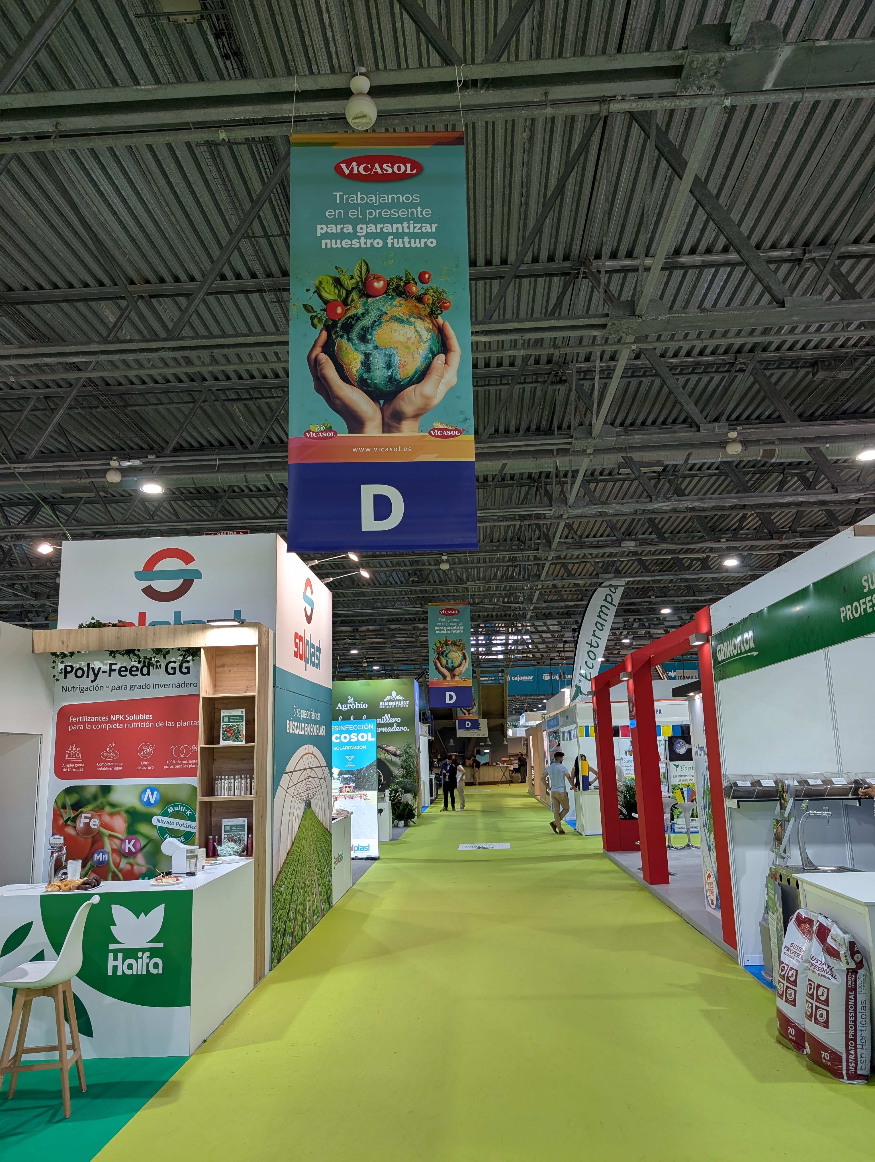 Cartelería colgante doble cara en pasillo principal con lona blockout FR en Infoagro 2025